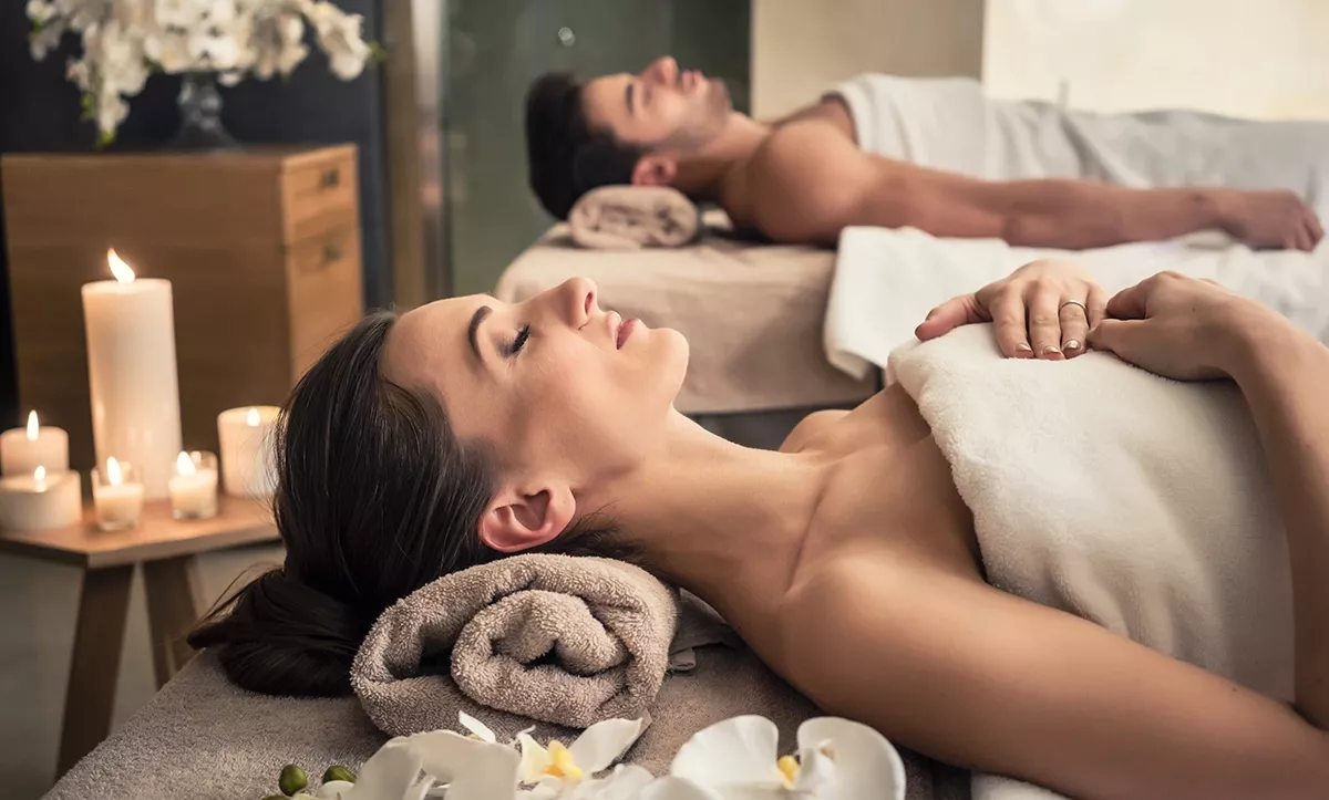 A man and woman lying down at a spa